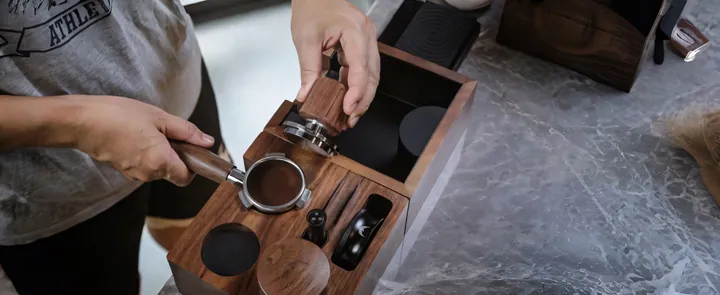 A walnut tamping station in use, tamper seated in its rest