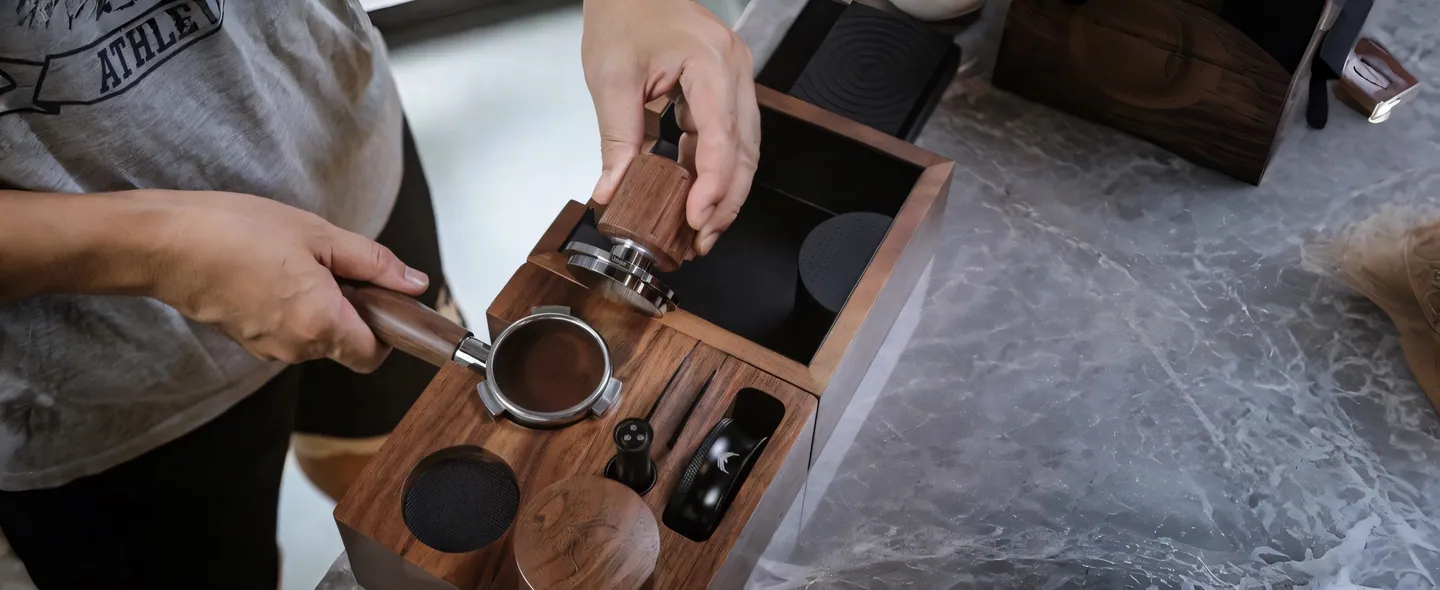 Hands seating a walnut tamper into a tamping station